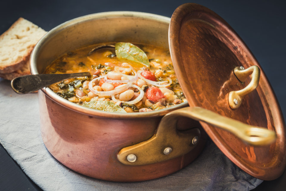 Soup with different vegetables, cannellini beans, kale, bread.Typical tuscan soup, ribollita in copper pot.