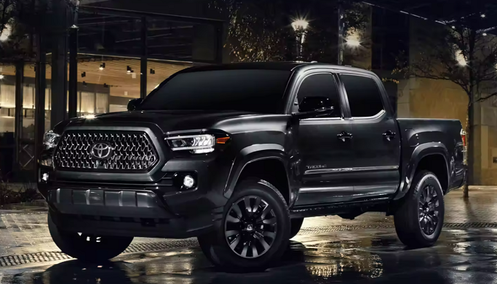 Black 2023 Toyota Tacoma parked on the street downtown at night